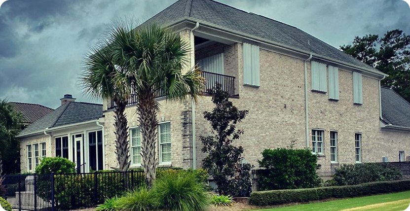 Accordion hurricane shutters on a brick home