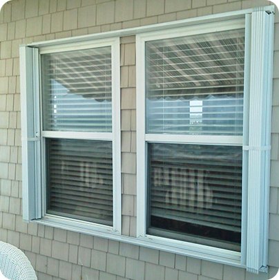Technician-level view of accordion hurricane shutters on a coastal home