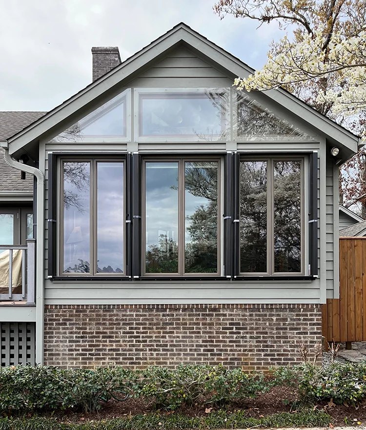 Accordion shutters beside a sliding glass door on a beach home
