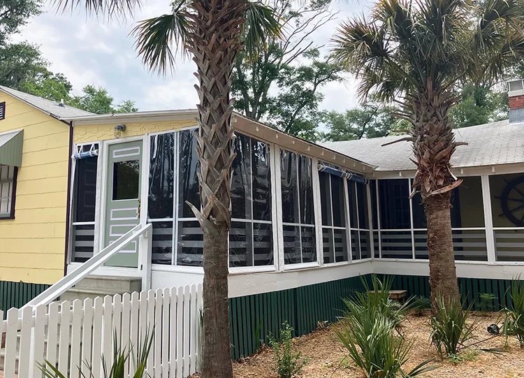 Clear vinyl curtains enclosing a coastal cottage porch
