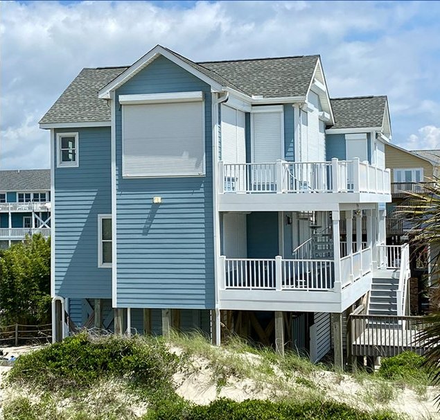 Coastal home protected with roll shutters