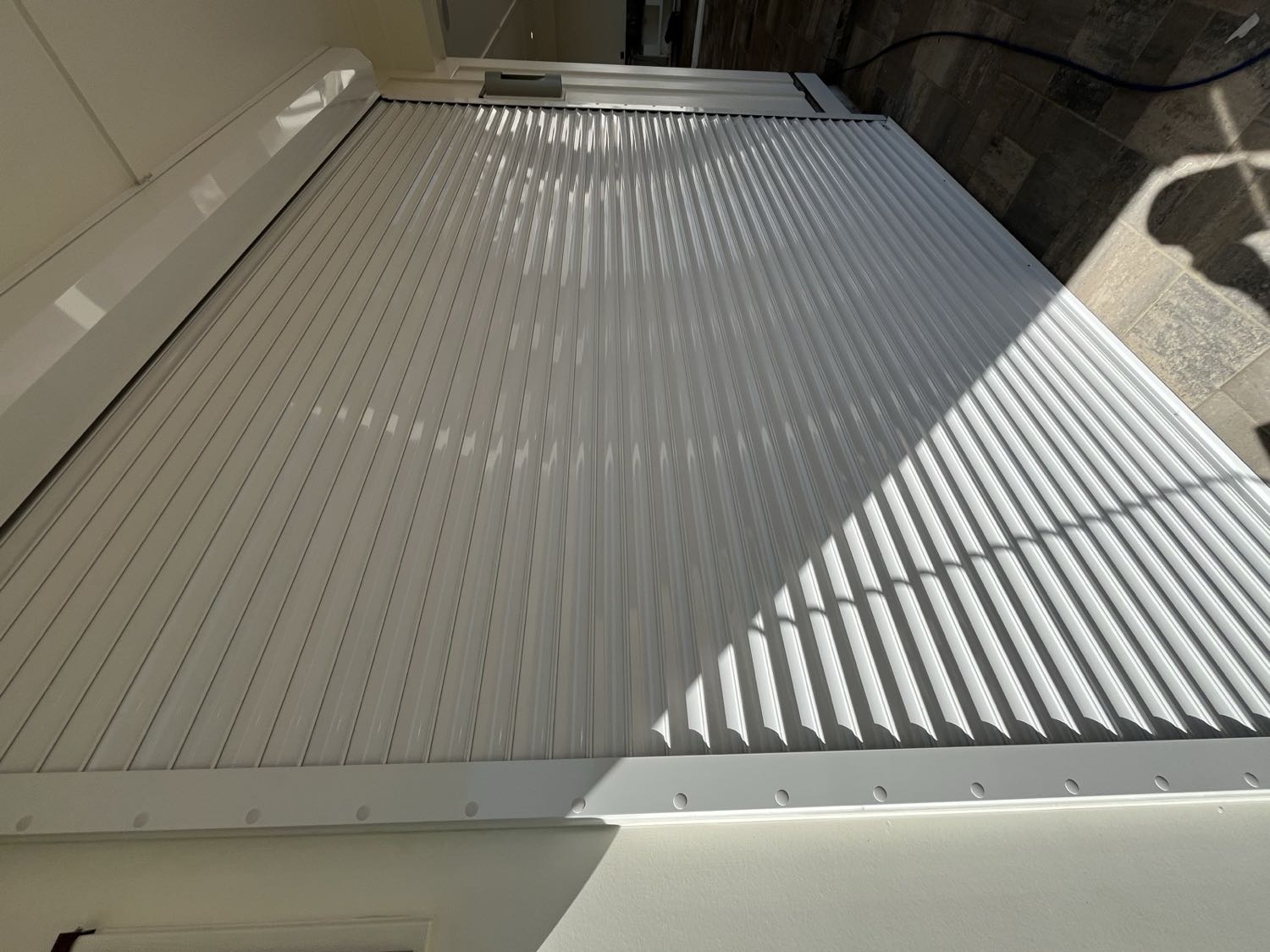 Roll shutters installed above the windows of a waterfront home