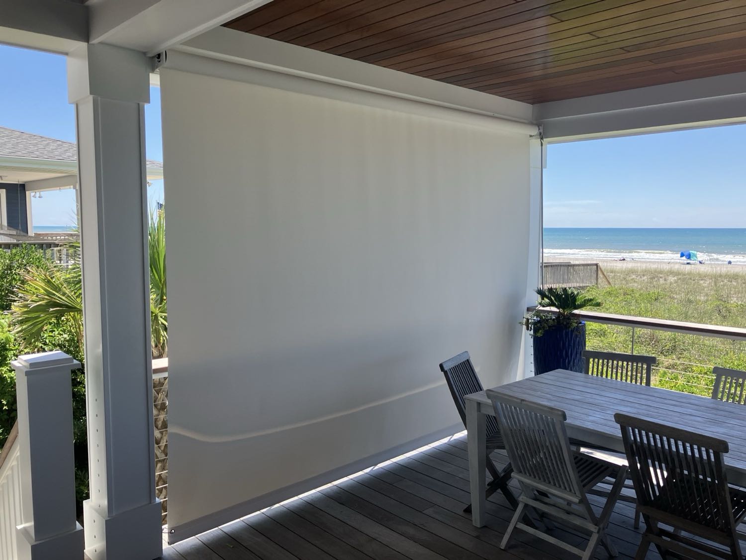 Rolling shade curtain lowered on a beachfront porch