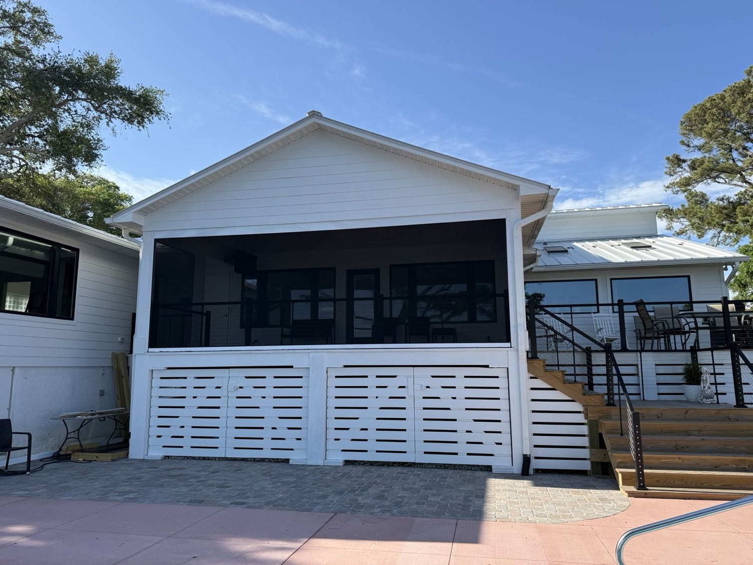 Motorized screens enclosing a coastal screened porch