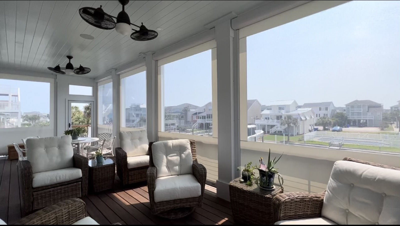 Screened coastal porch with motorized screens and seating