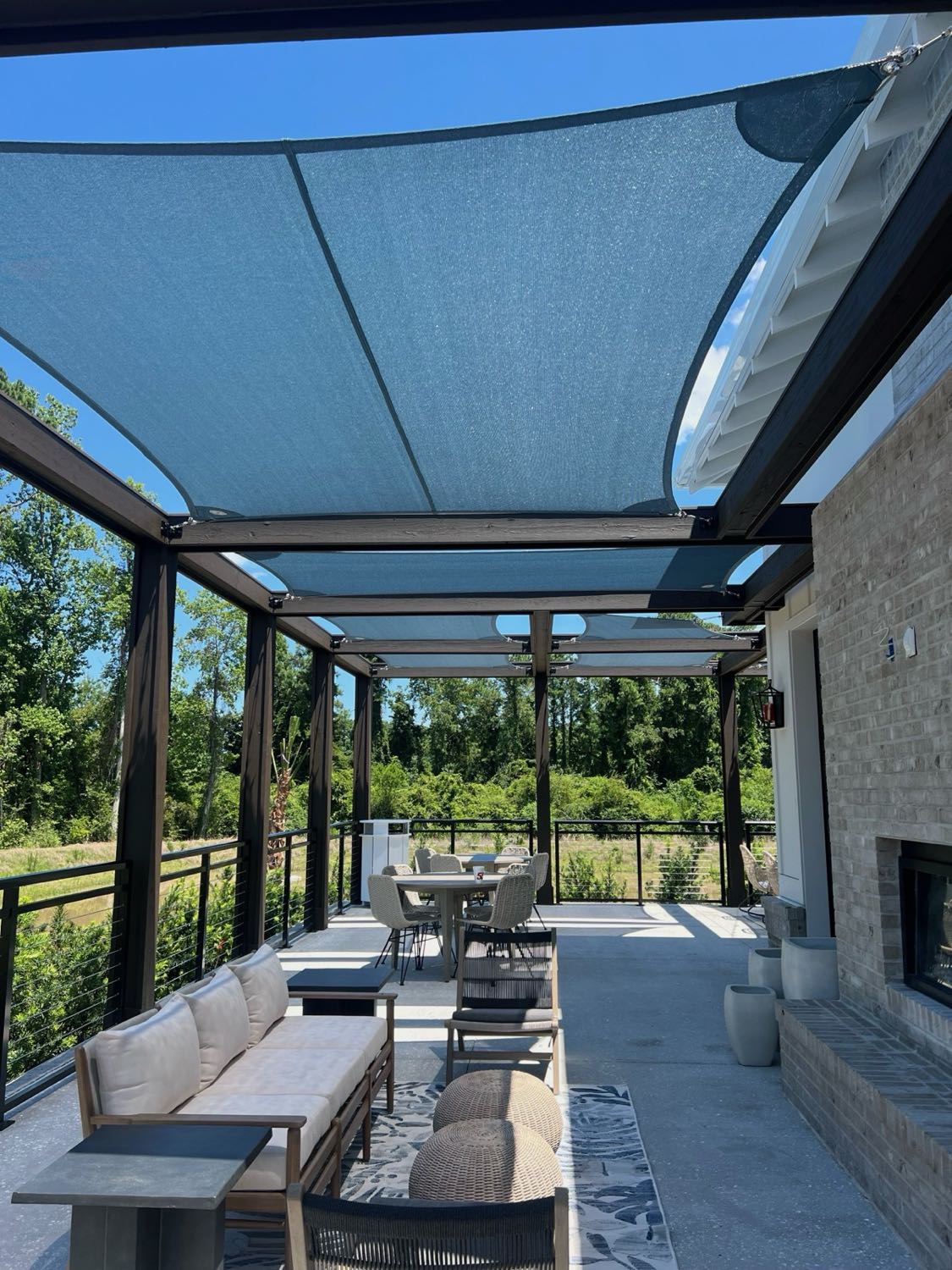Angled shade sails over an outdoor seating area