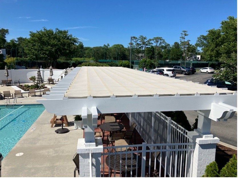 Fabric pergola shade cover over a poolside pergola