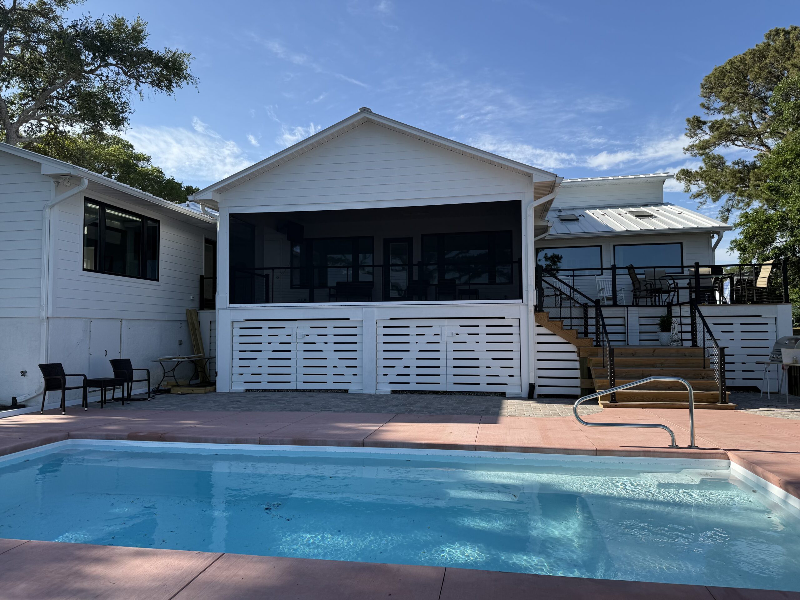 Modern house with swimming pool and outdoor seating.