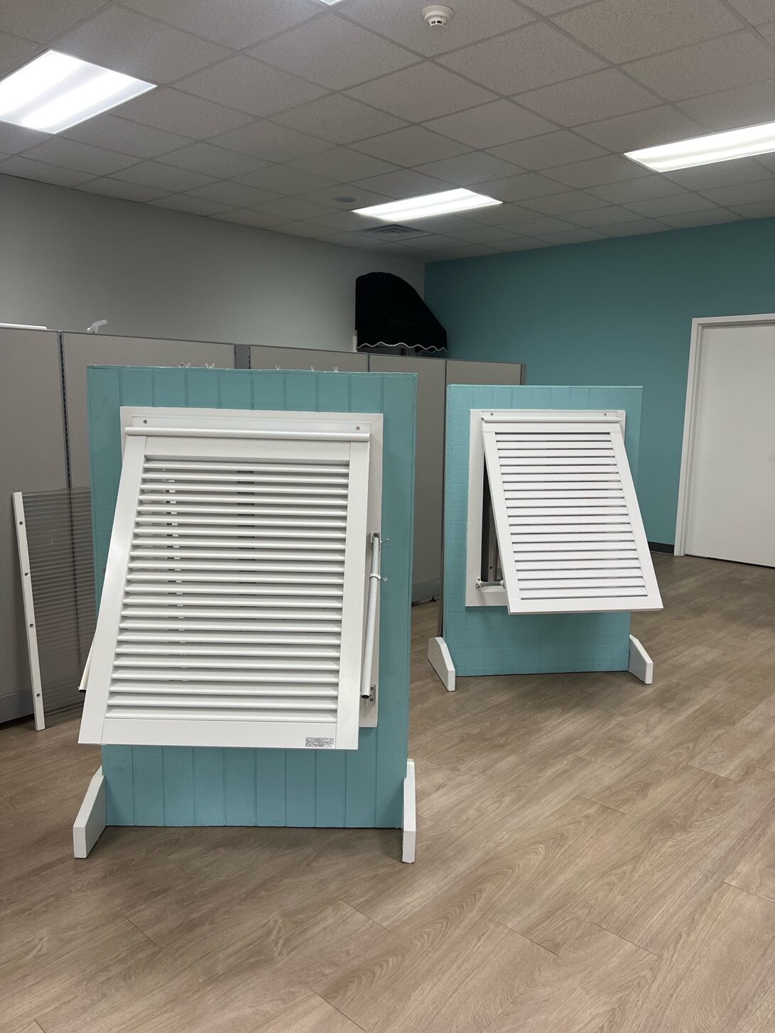 Showroom display with white shutters on stands.