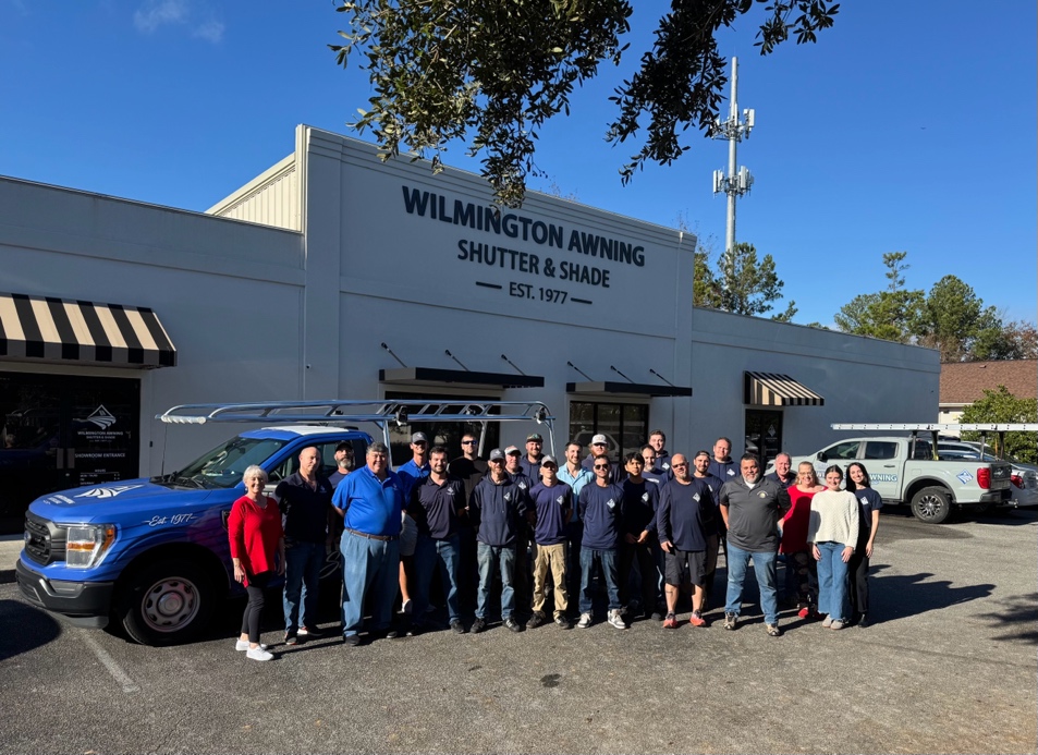 Wilmington Awning team outside building with company vehicles.
